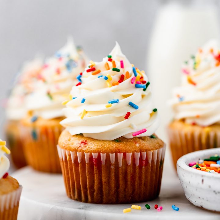 4 Funfetti Cupcakes with vanilla frosting and sprinkles