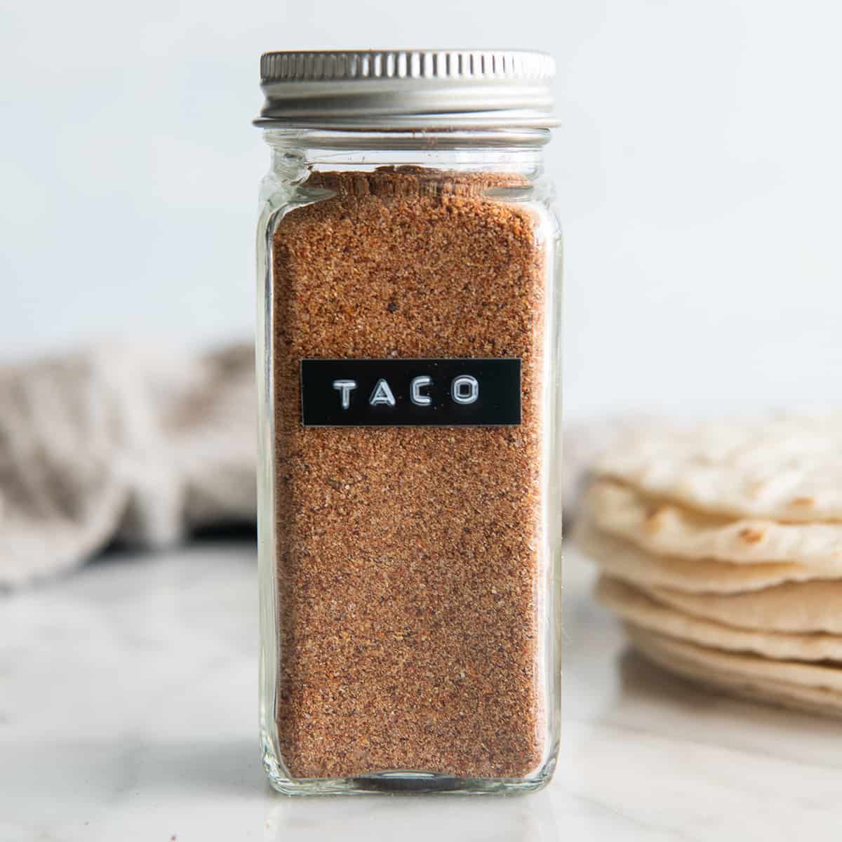a glass spice jar of Homemade Taco Seasoning with a label "taco"