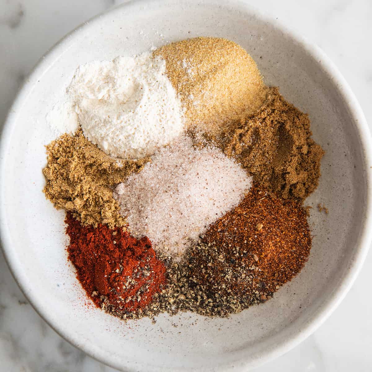 photo showing How to Make taco Seasoning - all the spices in a bowl before being mixed together. 
