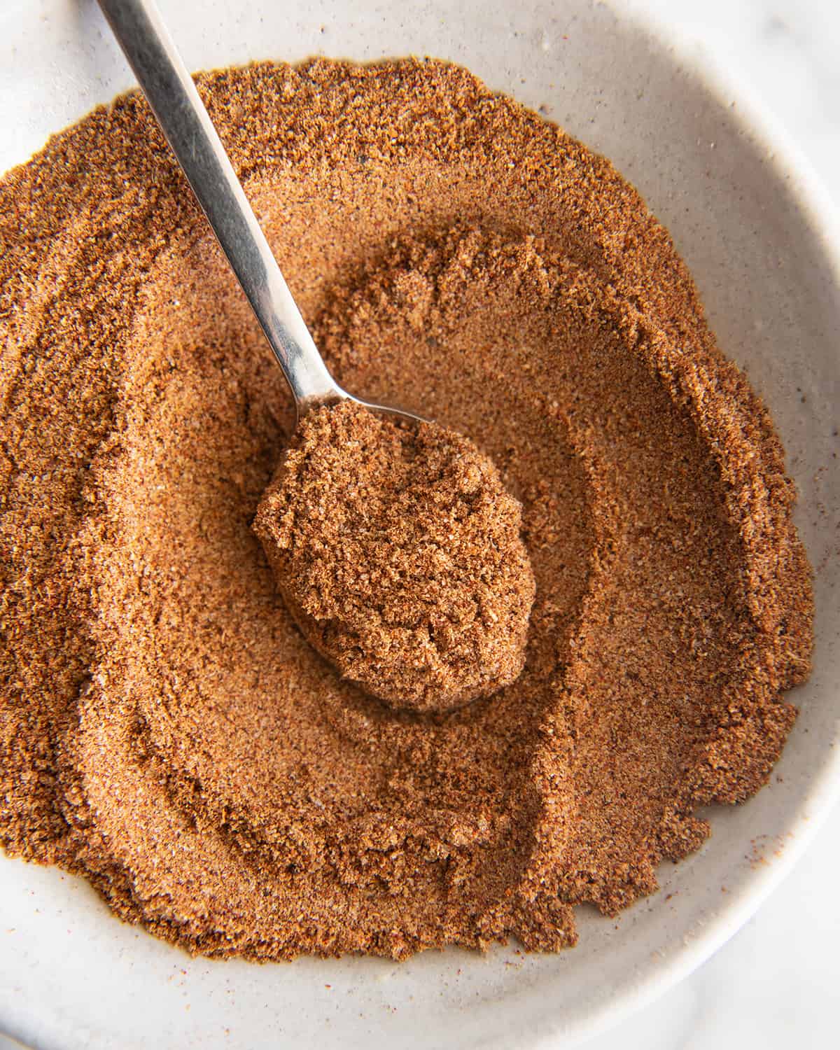 a bowl of Homemade Taco Seasoning after being mixed with a spoon in it