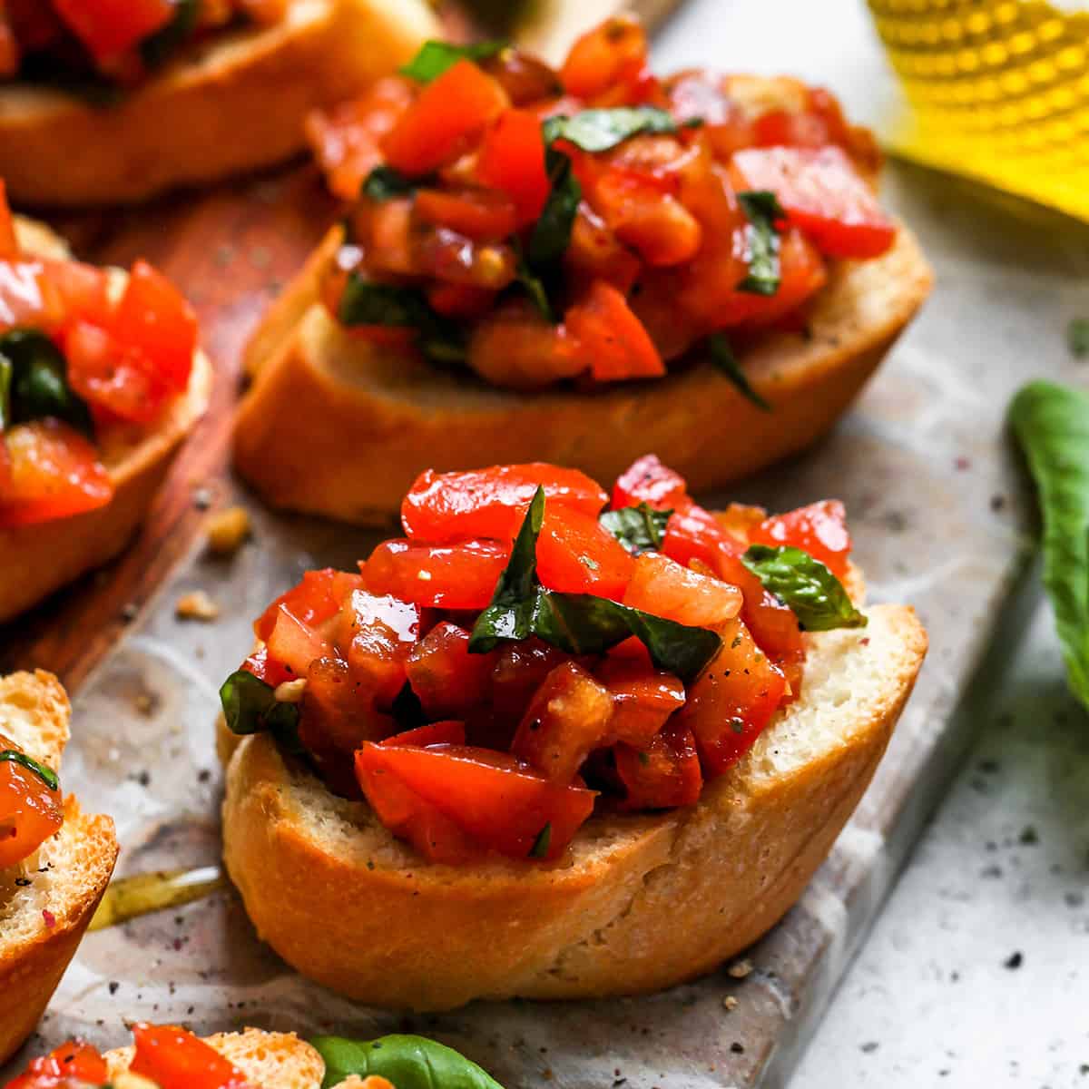 5 pieces of toasted bread topped with tomato bruschetta 