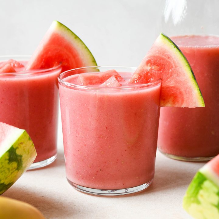 Watermelon Smoothie in three glass cups with slices of watermelon