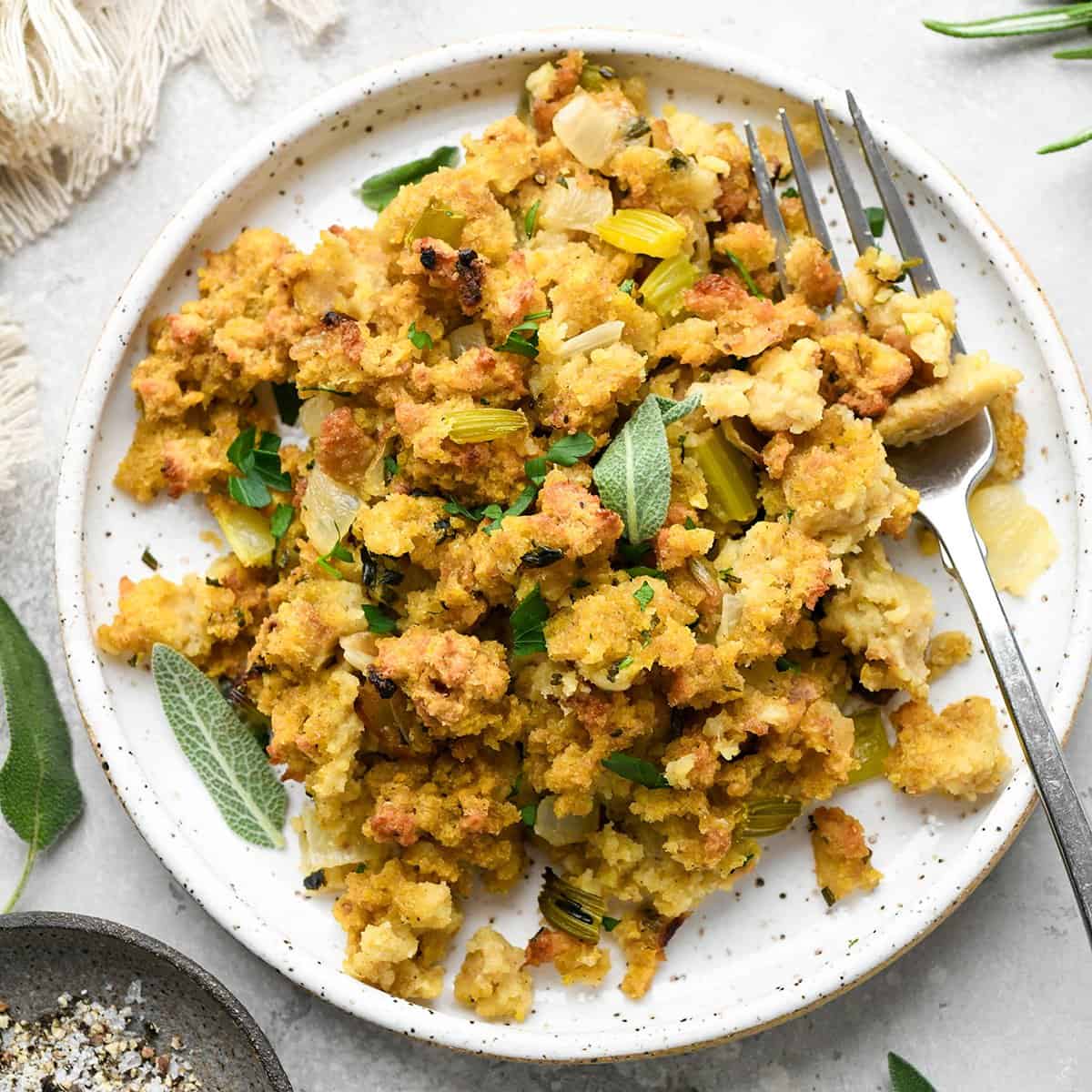 Cornbread Dressing  on a plate with fresh herbs 