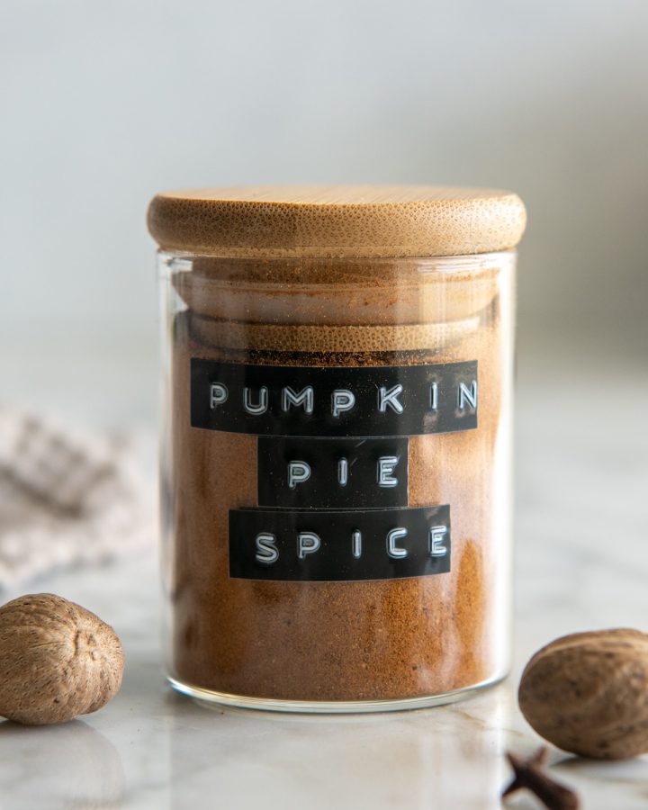 a glass jar of Homemade Pumpkin Pie Spice with a wooden lid and a black label 