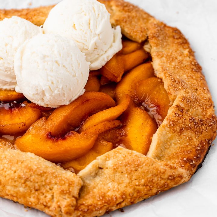 front view of a peach galette with vanilla ice cream on top