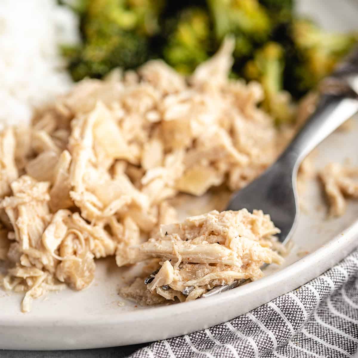 a fork scooping a bite of Slow Cooker Pulled Chicken