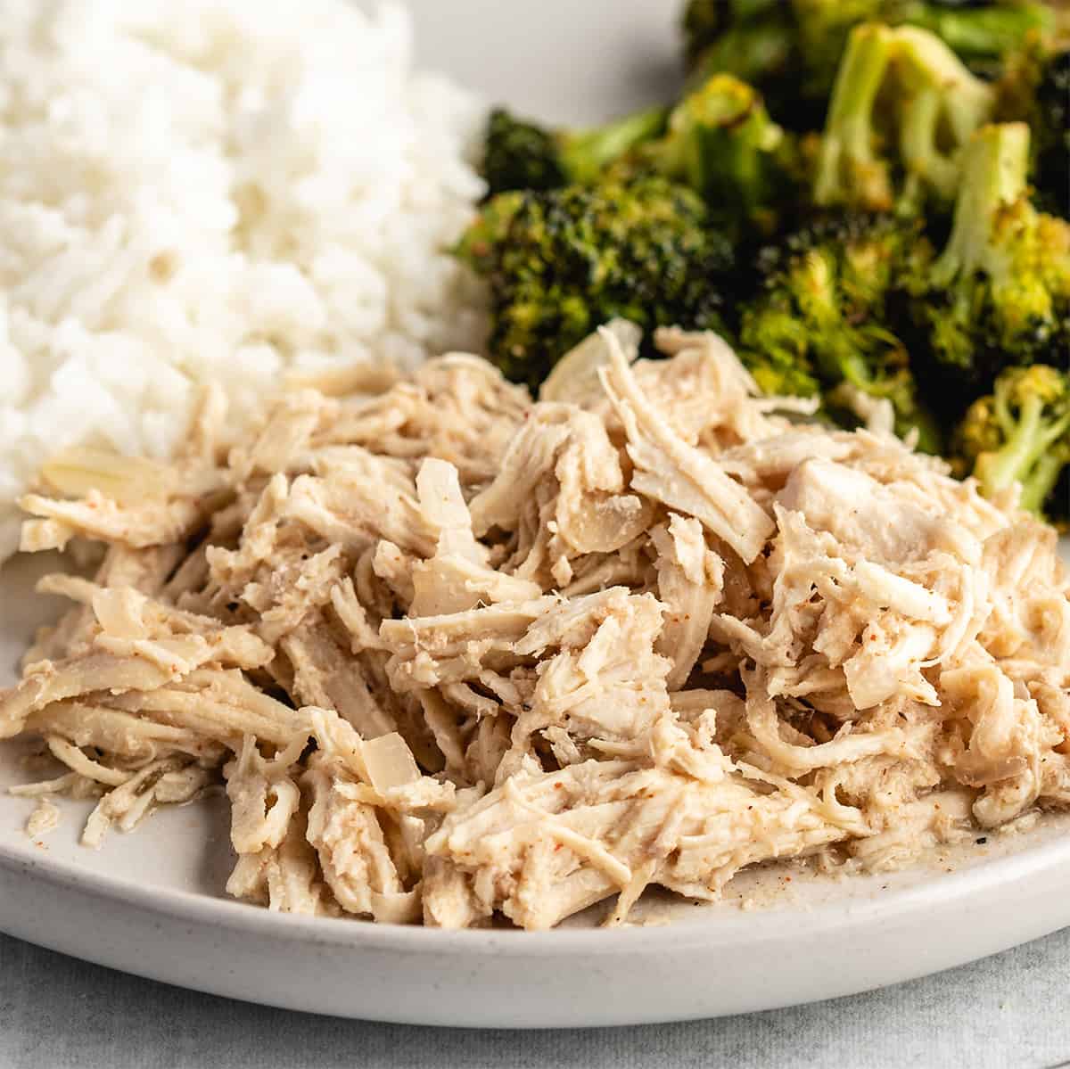 Slow Cooker Pulled Chicken on a plate with rice and broccoli