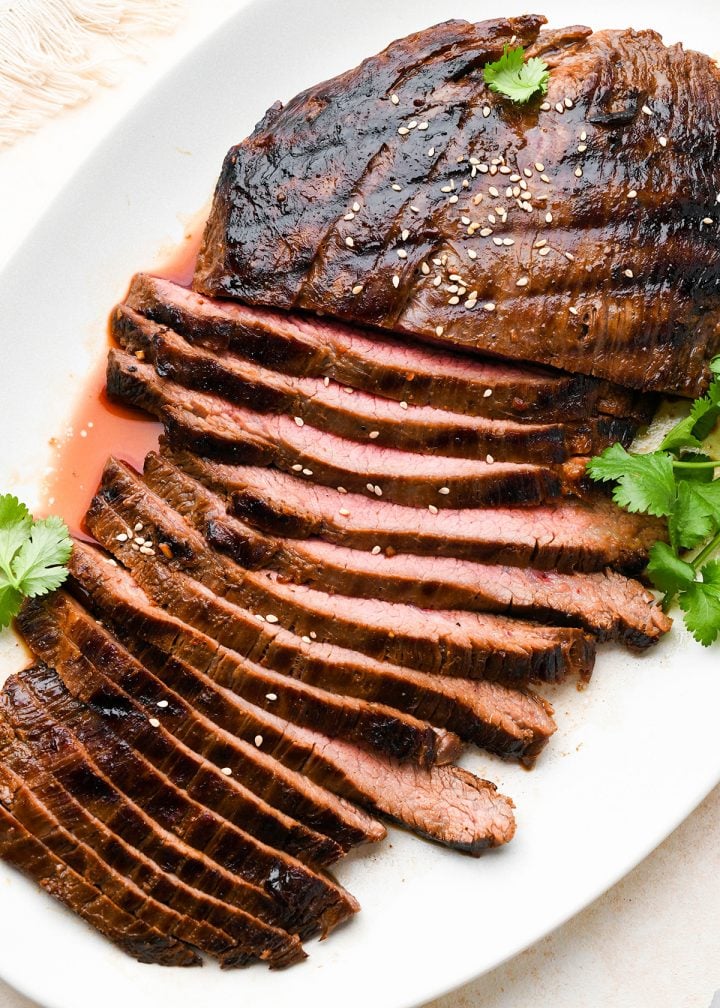 grilled flank steak sliced after soaking in an asian flank steak marinade