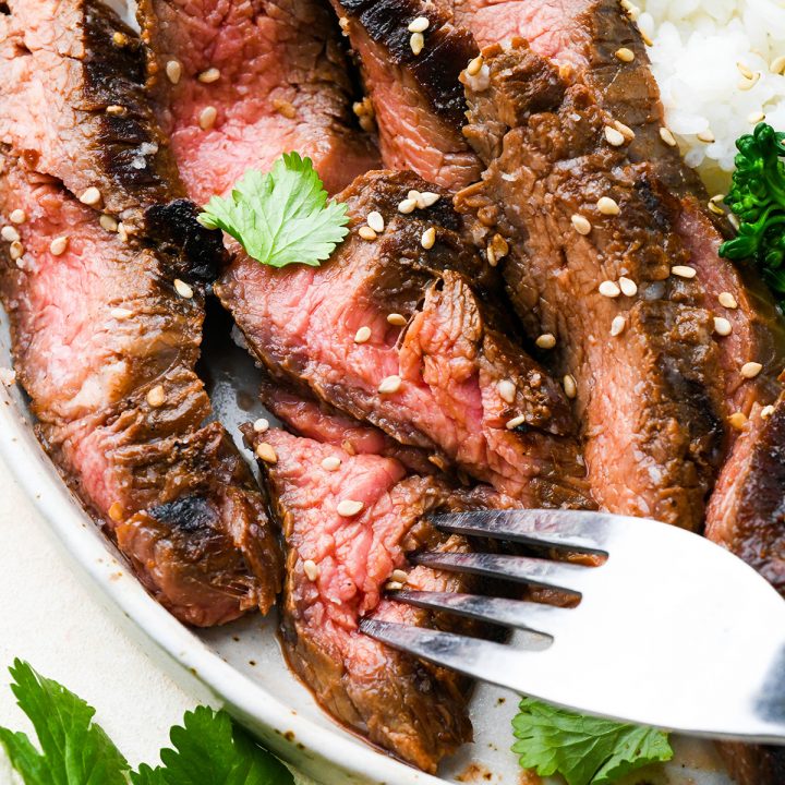 4 slices of grilled flank steak after soaking in an asian flank steak marinade
