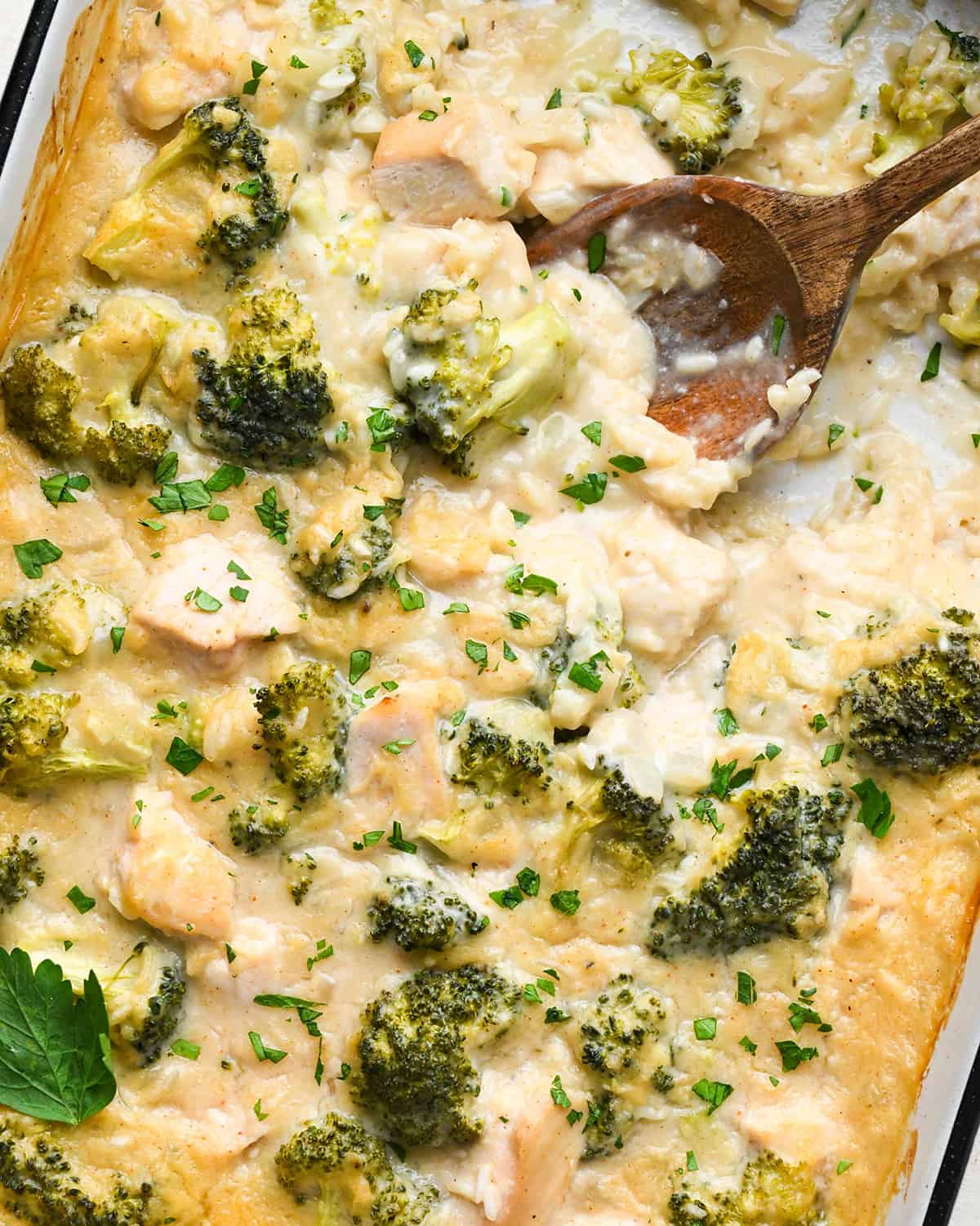 Broccoli Chicken and Rice Casserole in a baking dish with a wooden spoon