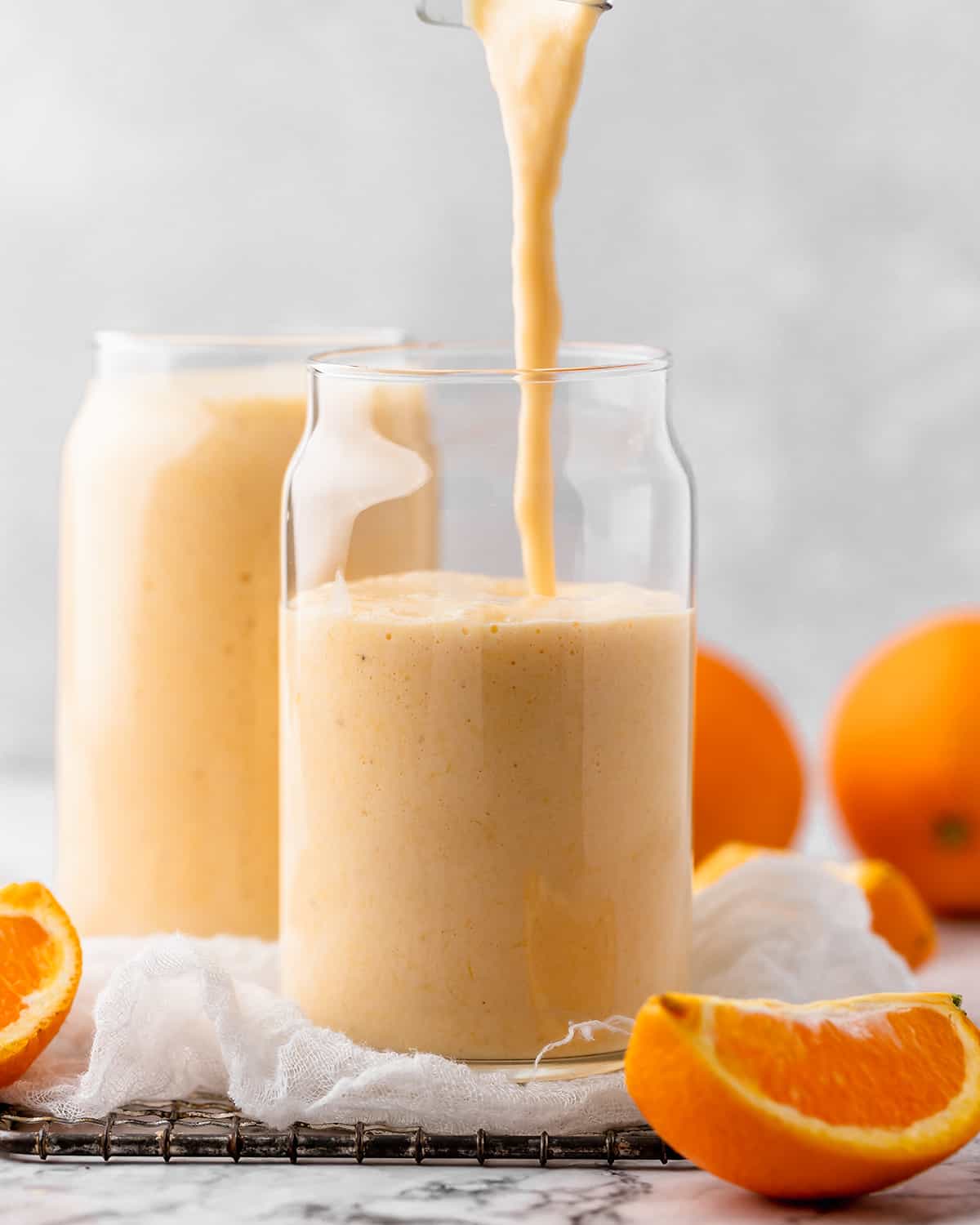 Banana Orange Smoothie being poured into a glass