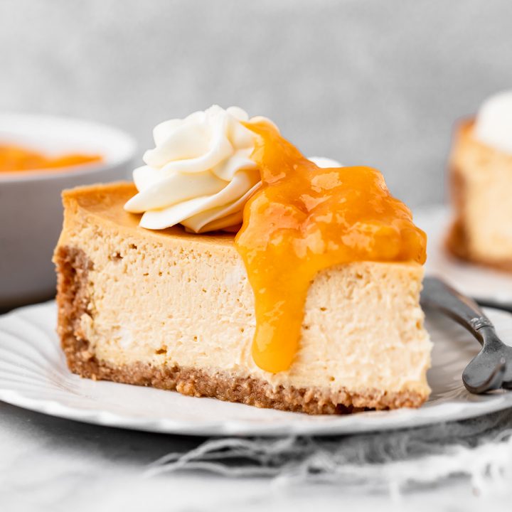a slice of Peach Cheesecake with peach topping and whipped cream