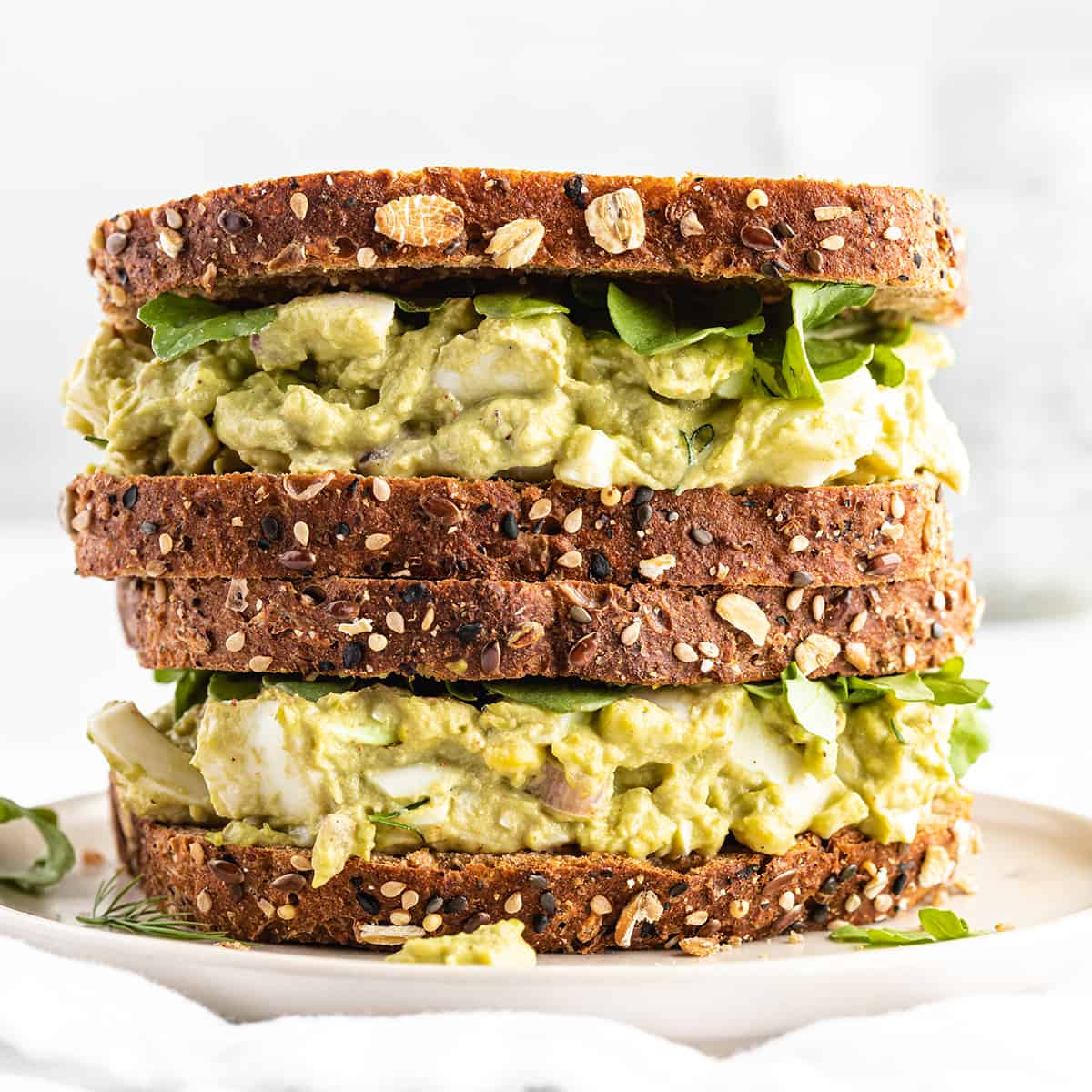 two Avocado Egg Salad sandwiches stacked on each other 