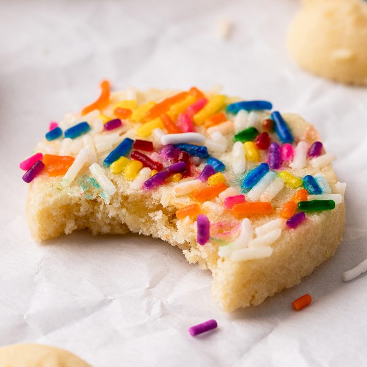 a butter cookie with sprinkles and a bite taken out of it