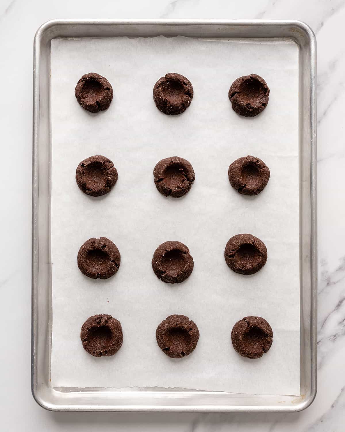 chocolate thumbprint cookies on a baking sheet 