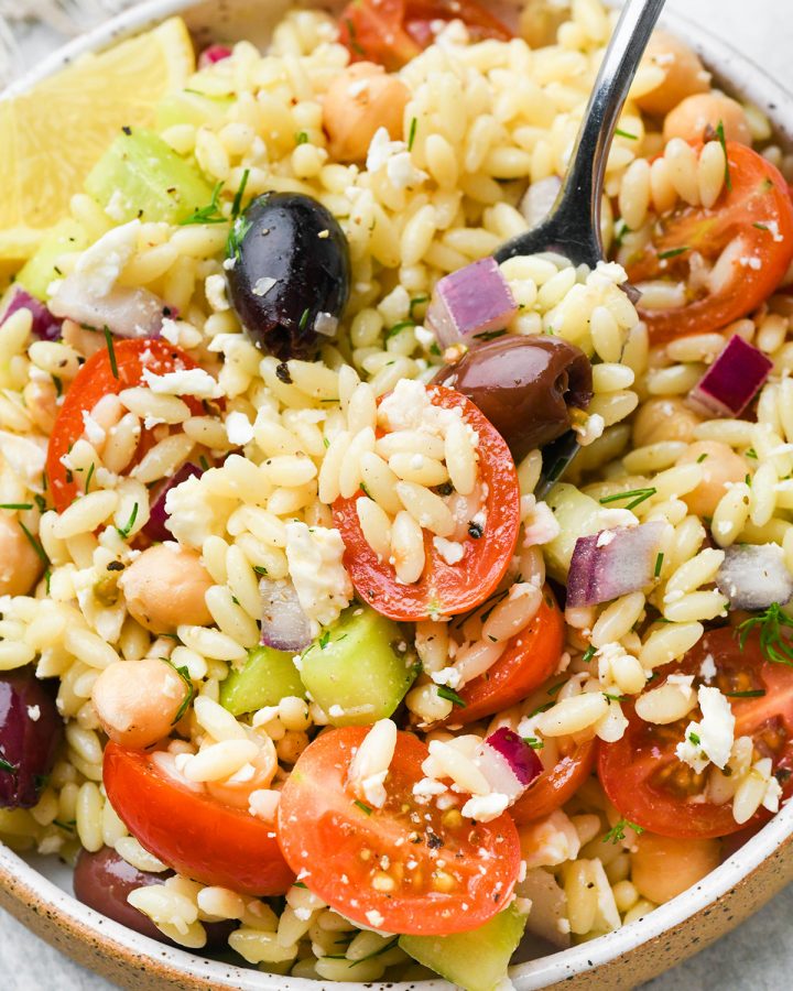 a fork taking a bite of this Greek Orzo Salad Recipe