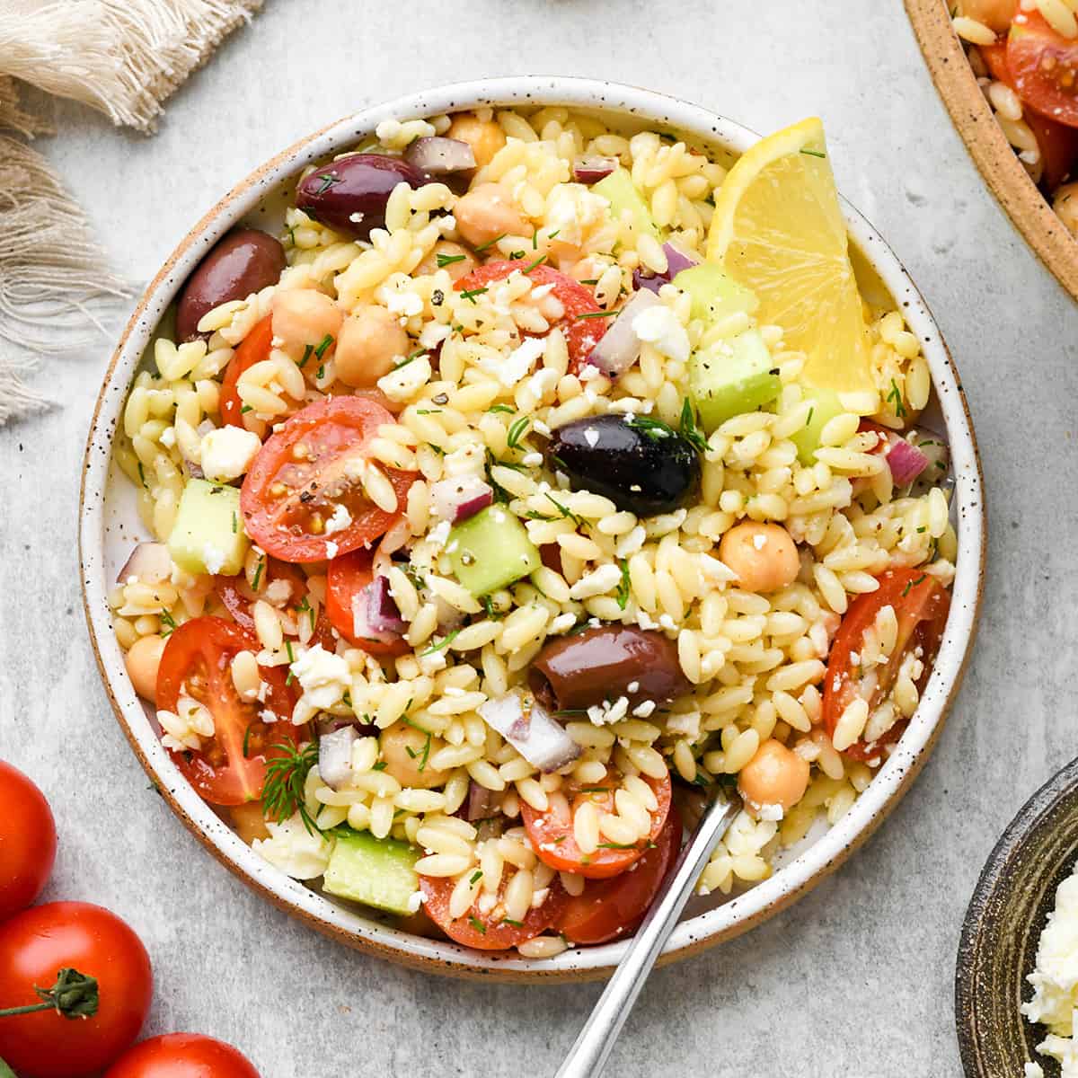 Greek Orzo Salad in a bowl with a fork