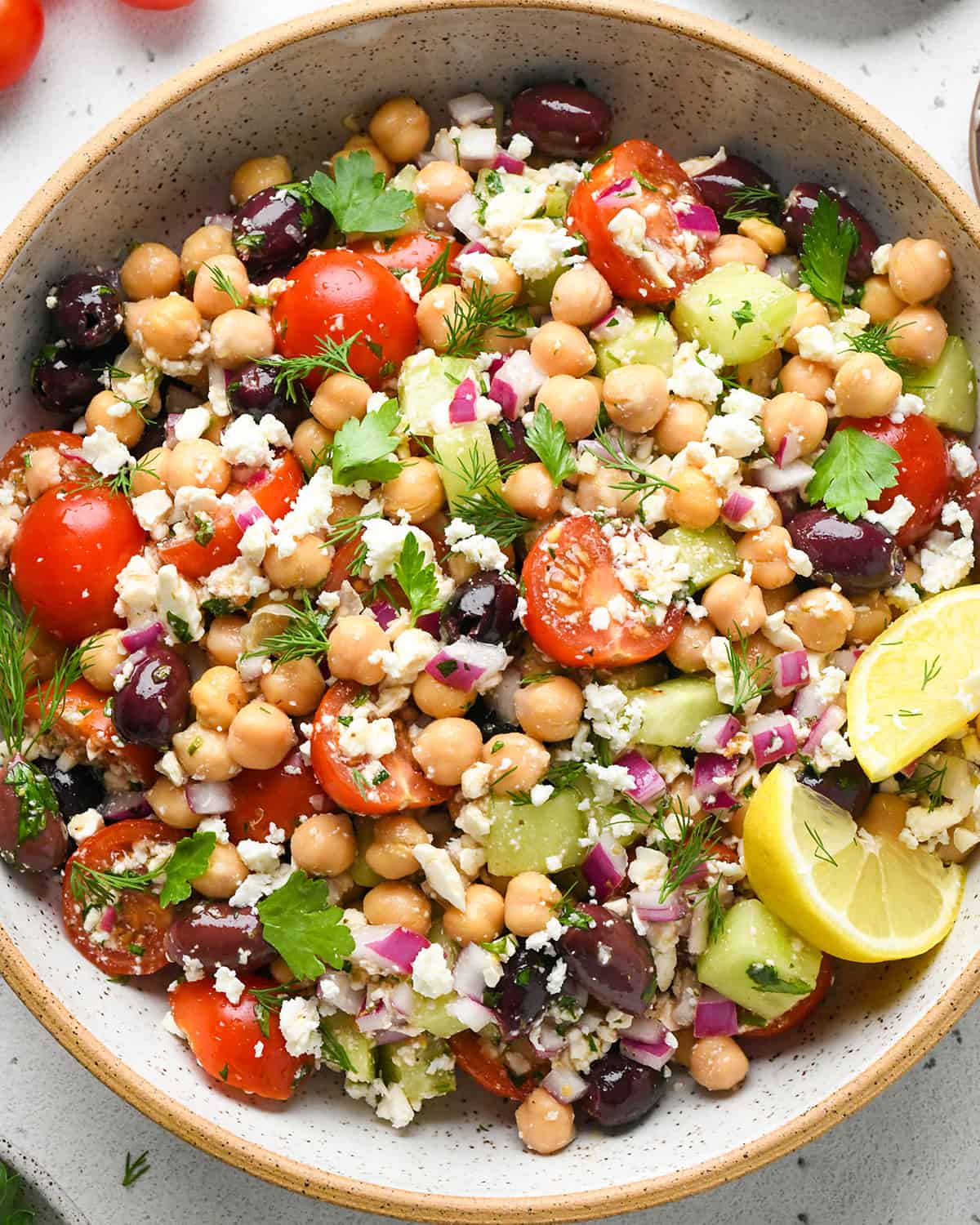 Mediterranean Chickpea Salad in a bowl garnished with dill and parsley
