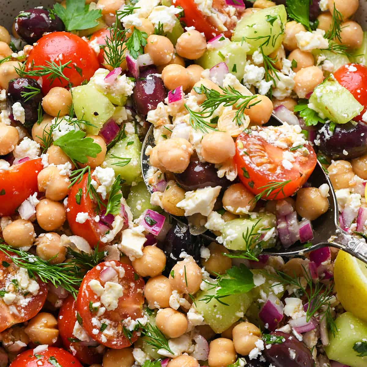 a spoon taking a scoop of Mediterranean Chickpea Salad