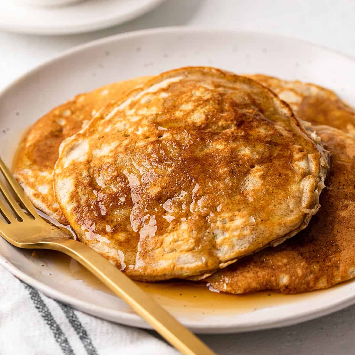Zucchini Pancakes on a plate with maple syrup 