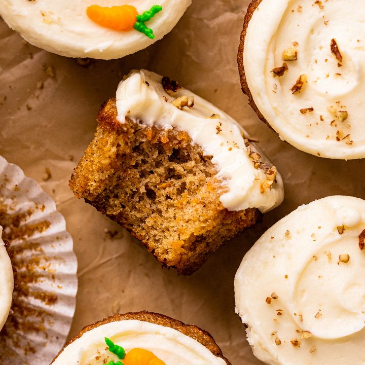 a carrot cake cupcake with a bite taken out of it