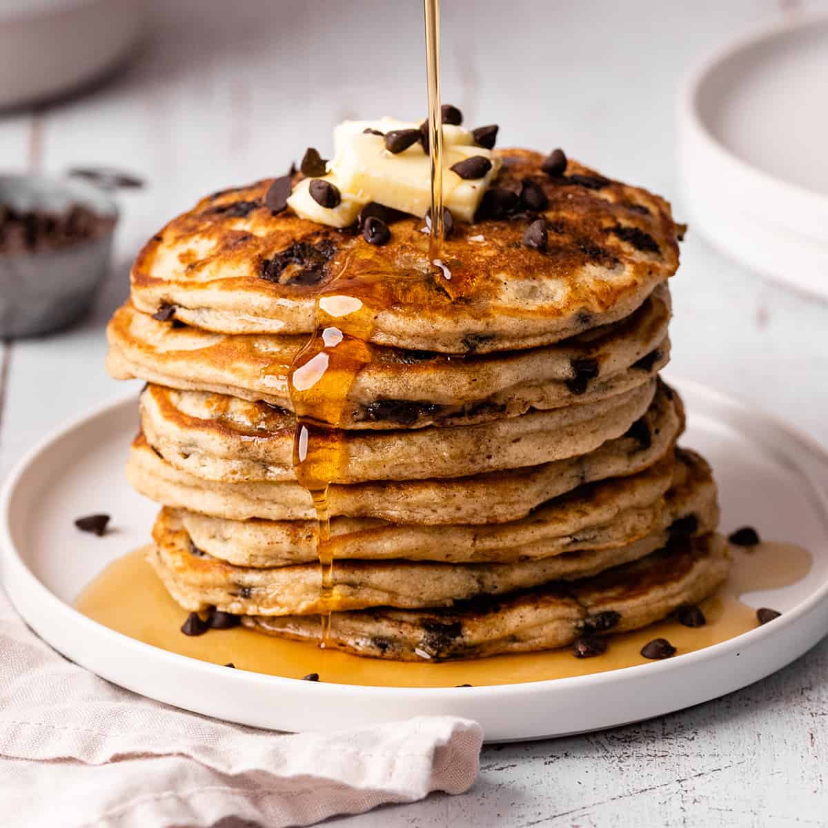a stack of 7 Chocolate Chip Pancakes with butter and syrup