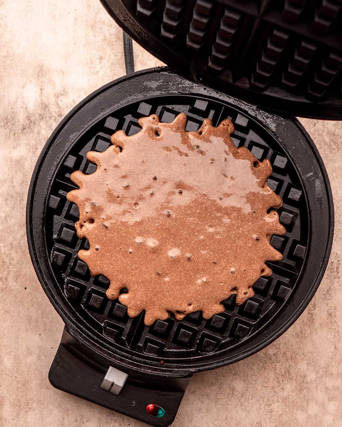 chocolate waffle batter in a waffle maker before cooking