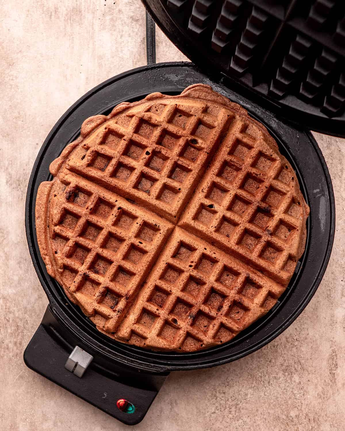 chocolate waffle batter in a waffle maker after cooking