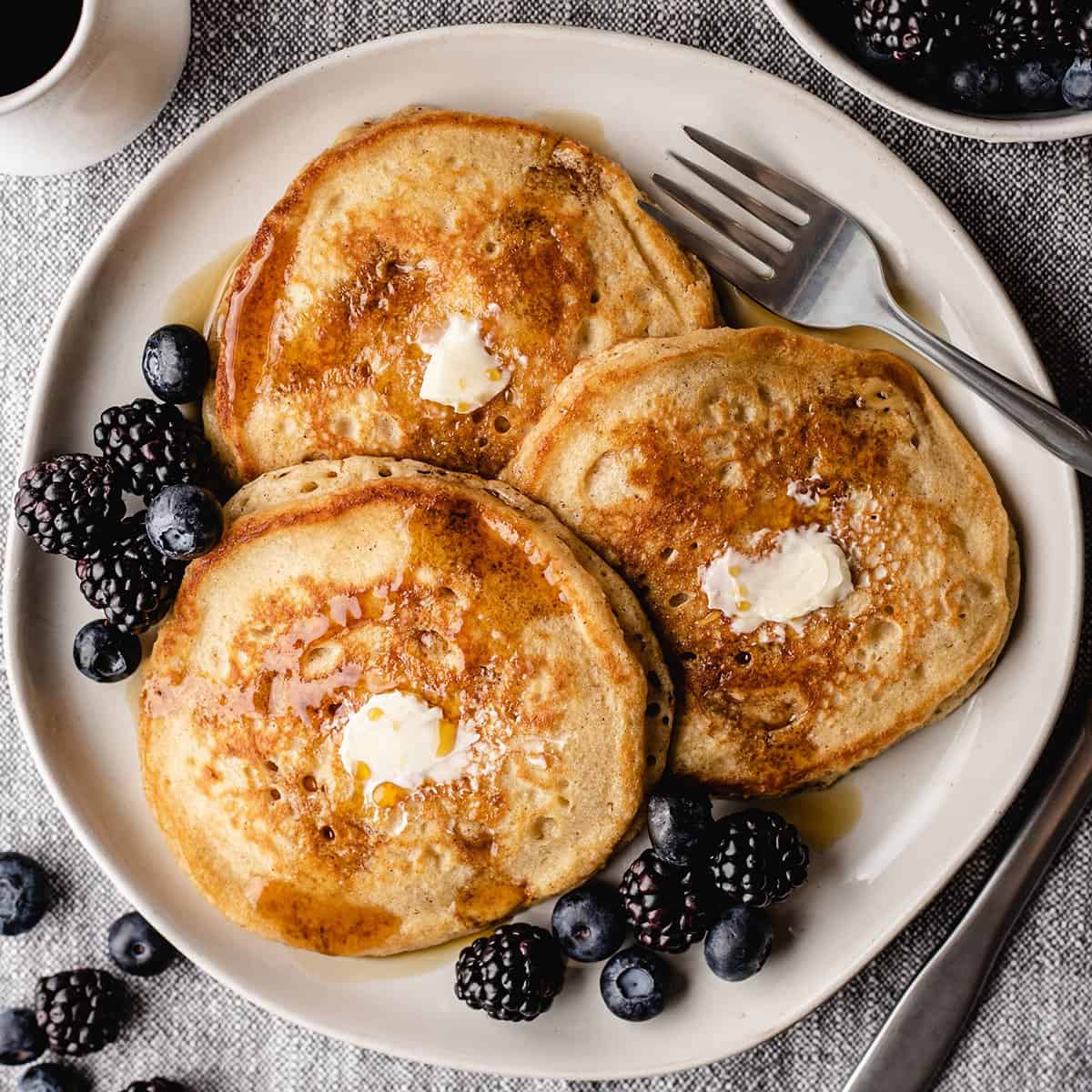 3 homemade pancakes on a plate with butter and syrup 