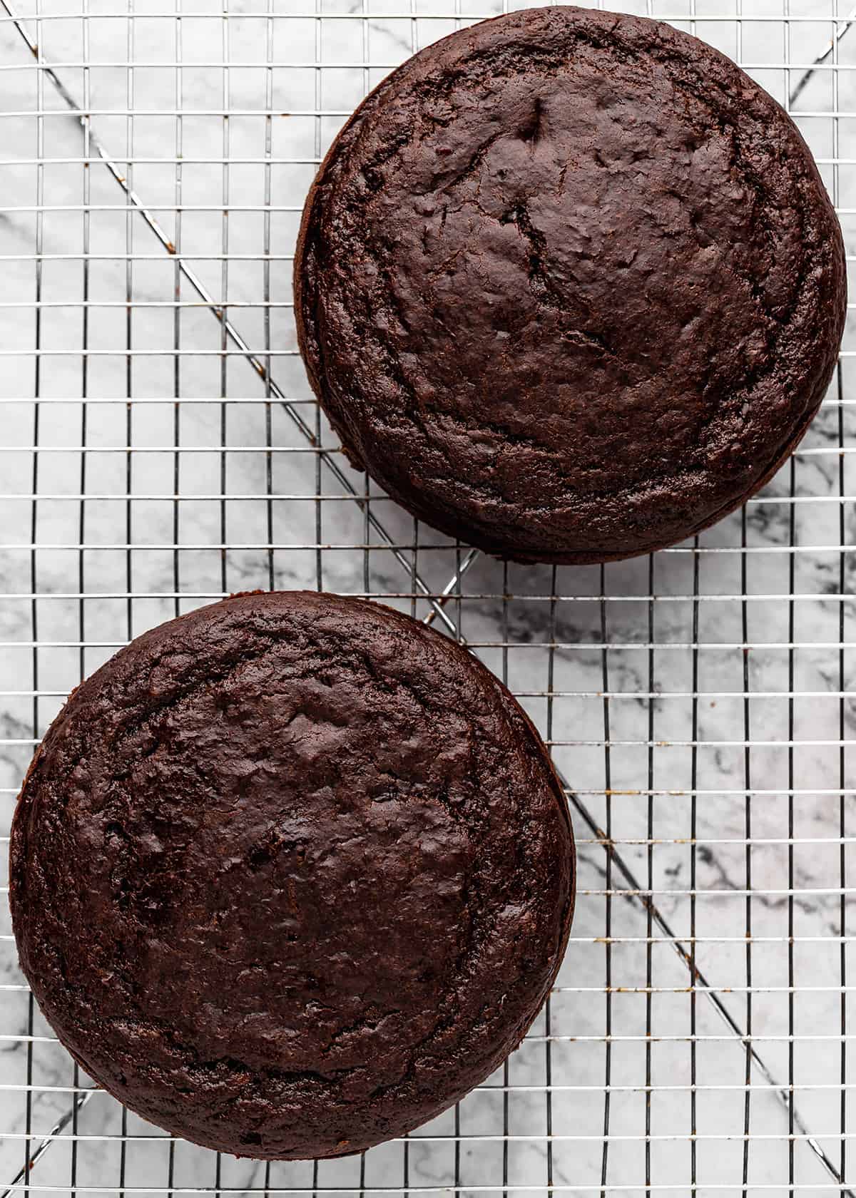 two Healthy Chocolate Cake rounds cooling on a wire cooling rack