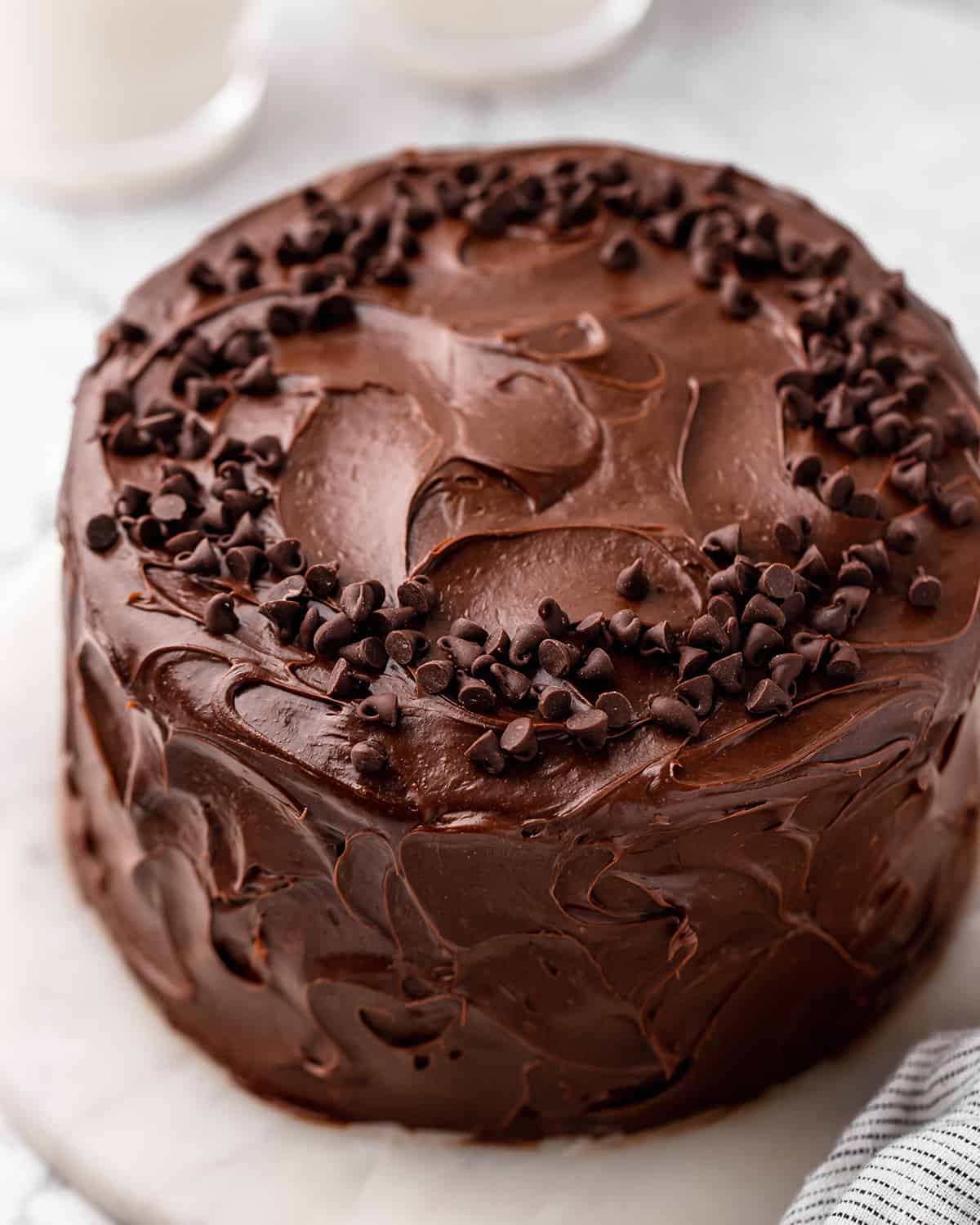 Healthy Chocolate Cake frosting and decorated with chocolate chips