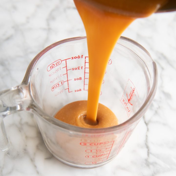 caramel pouring into a glass pyrex cup