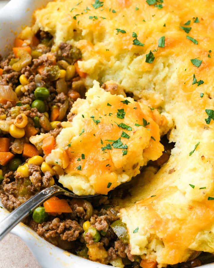 up close view of a spoon taking a scoop of Shepherd's Pie out of a pie dish