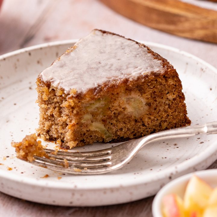 a slice of Apple Cake on a plate with a bite taken out of it and a fork 