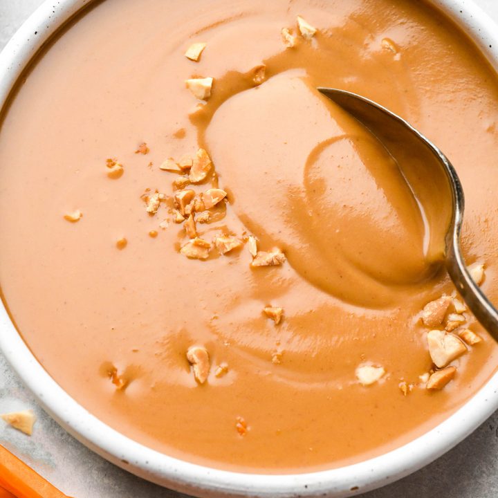 a bowl of peanut sauce with a spoon