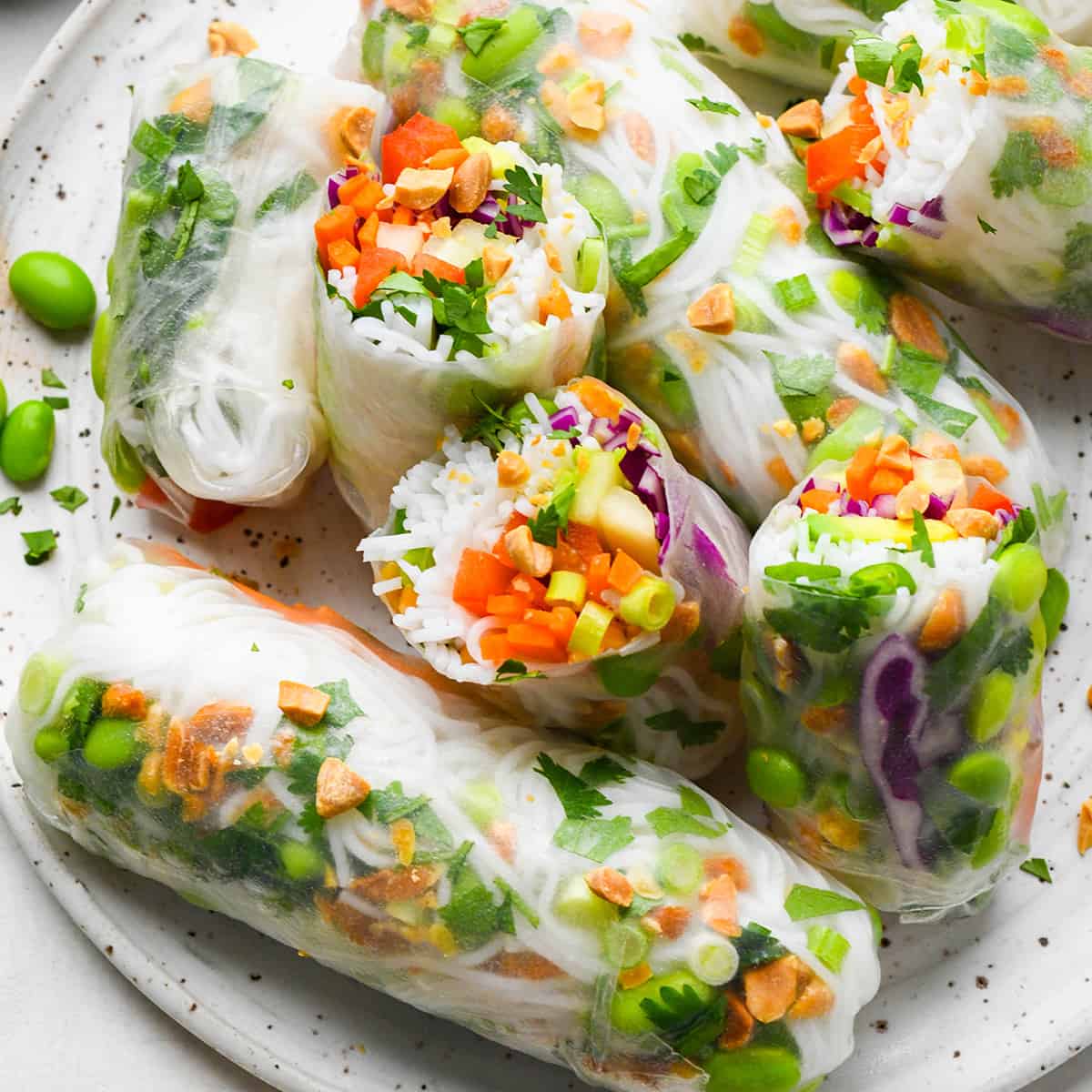 5 Spring Rolls on a plate, one cut in half so the inside is showing