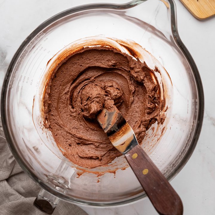 whipped chocolate ganache in a glass mixing bowl
