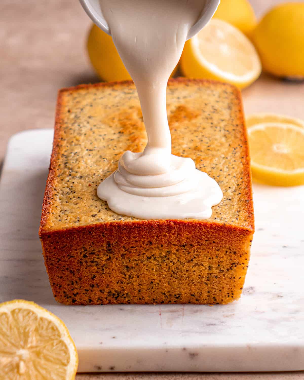 glaze being poured on top of Lemon Poppy Seed Bread