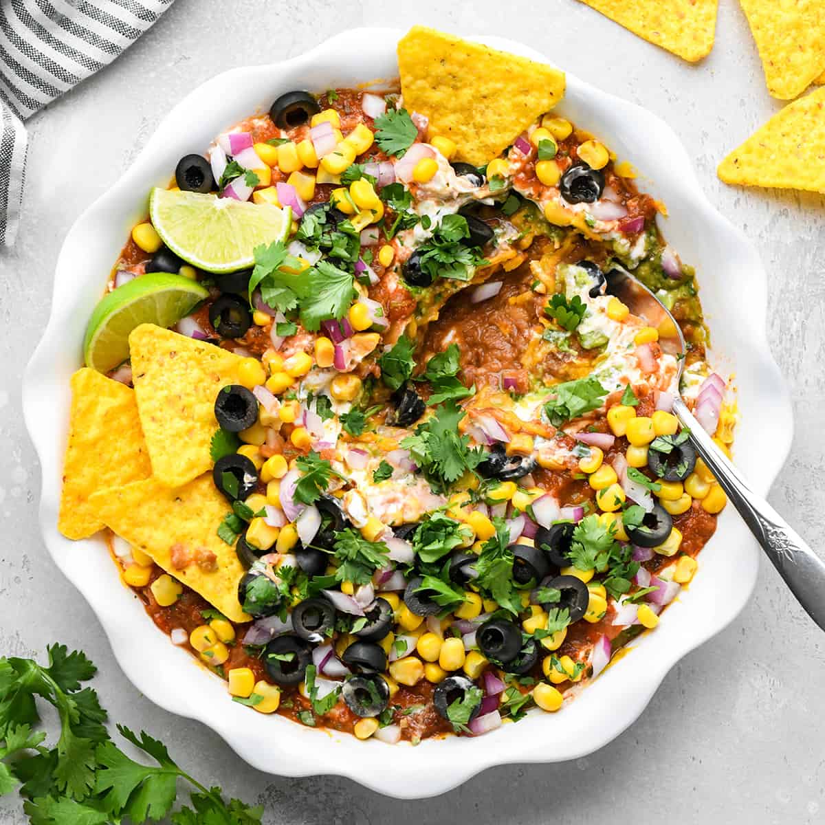 Mexican 7 Layer Dip in a serving dish with a spoon