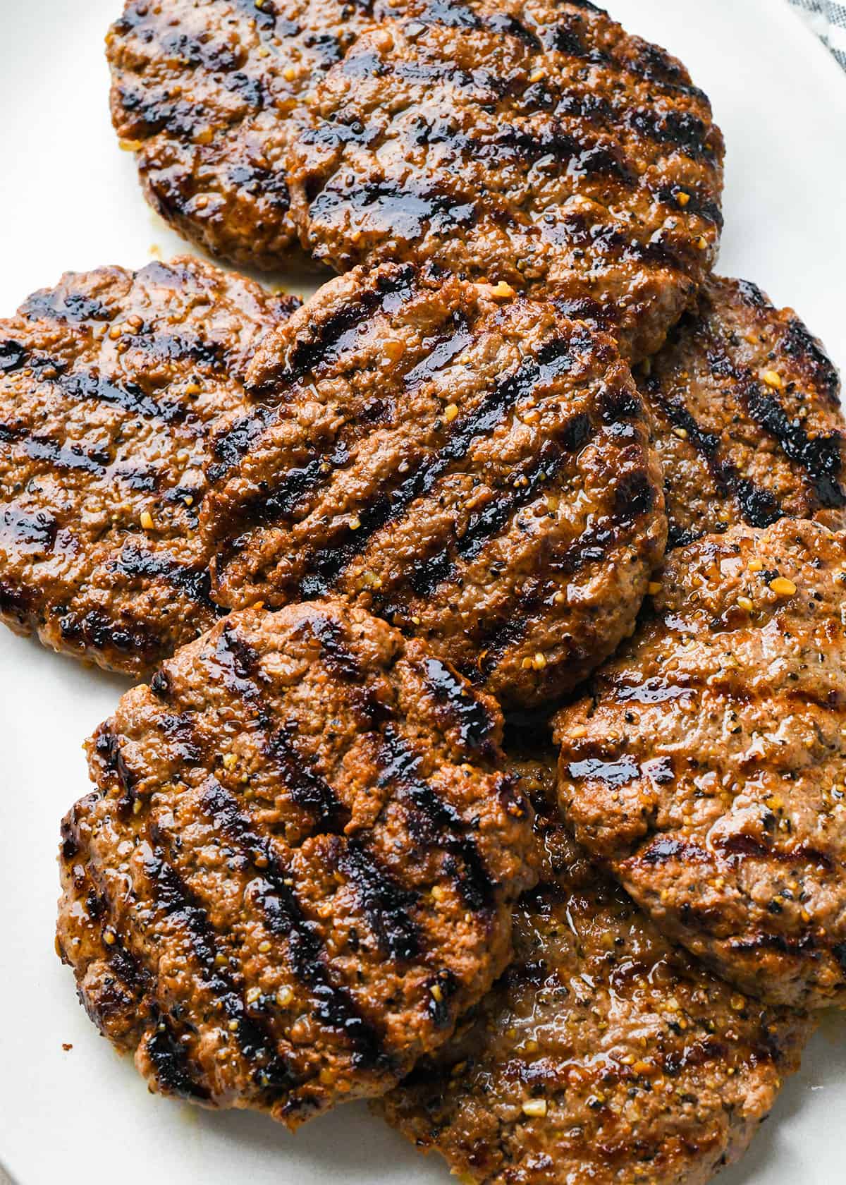 8 grilled hamburger patties on a plate