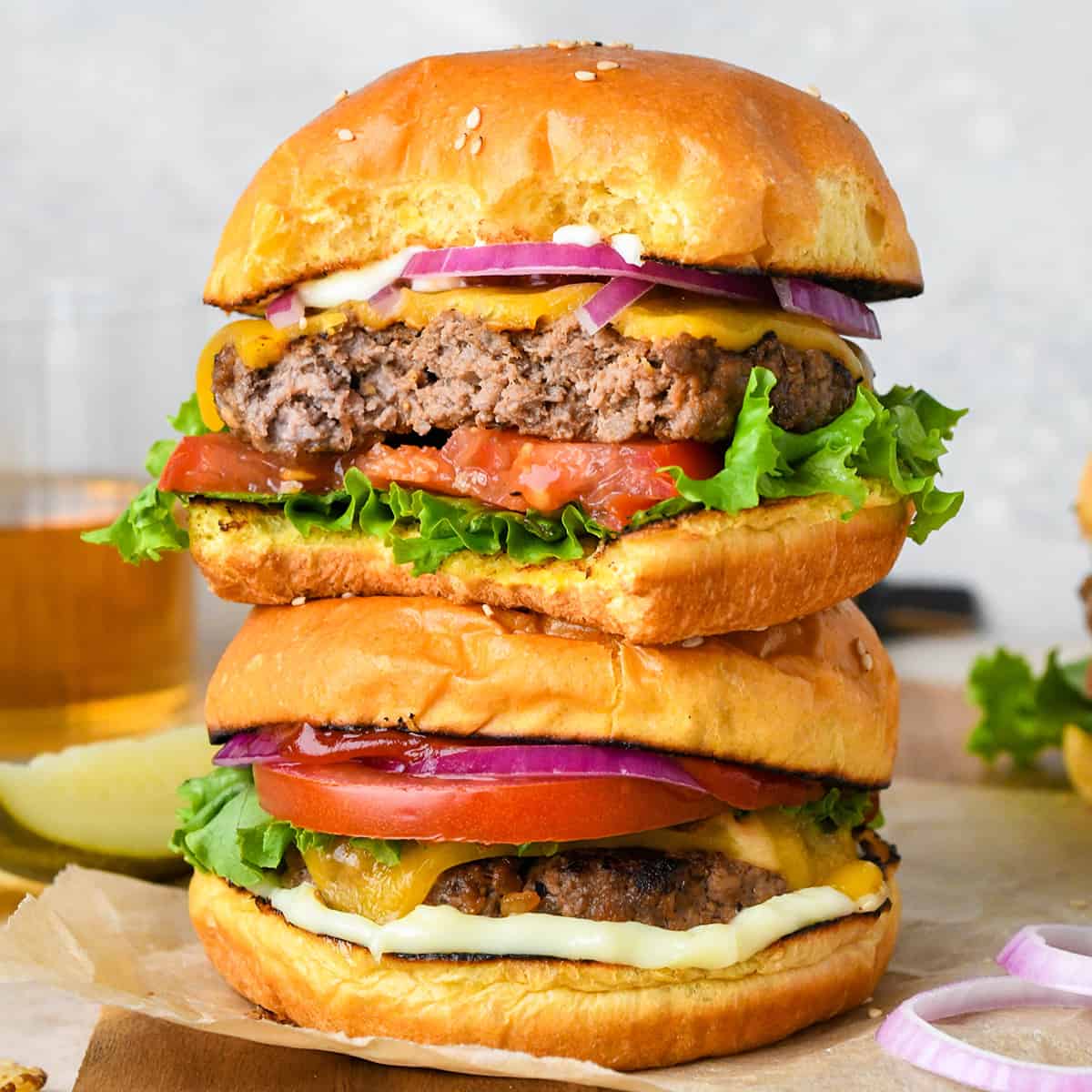 a stack of two hamburgers, the top one has a bite taken out of it