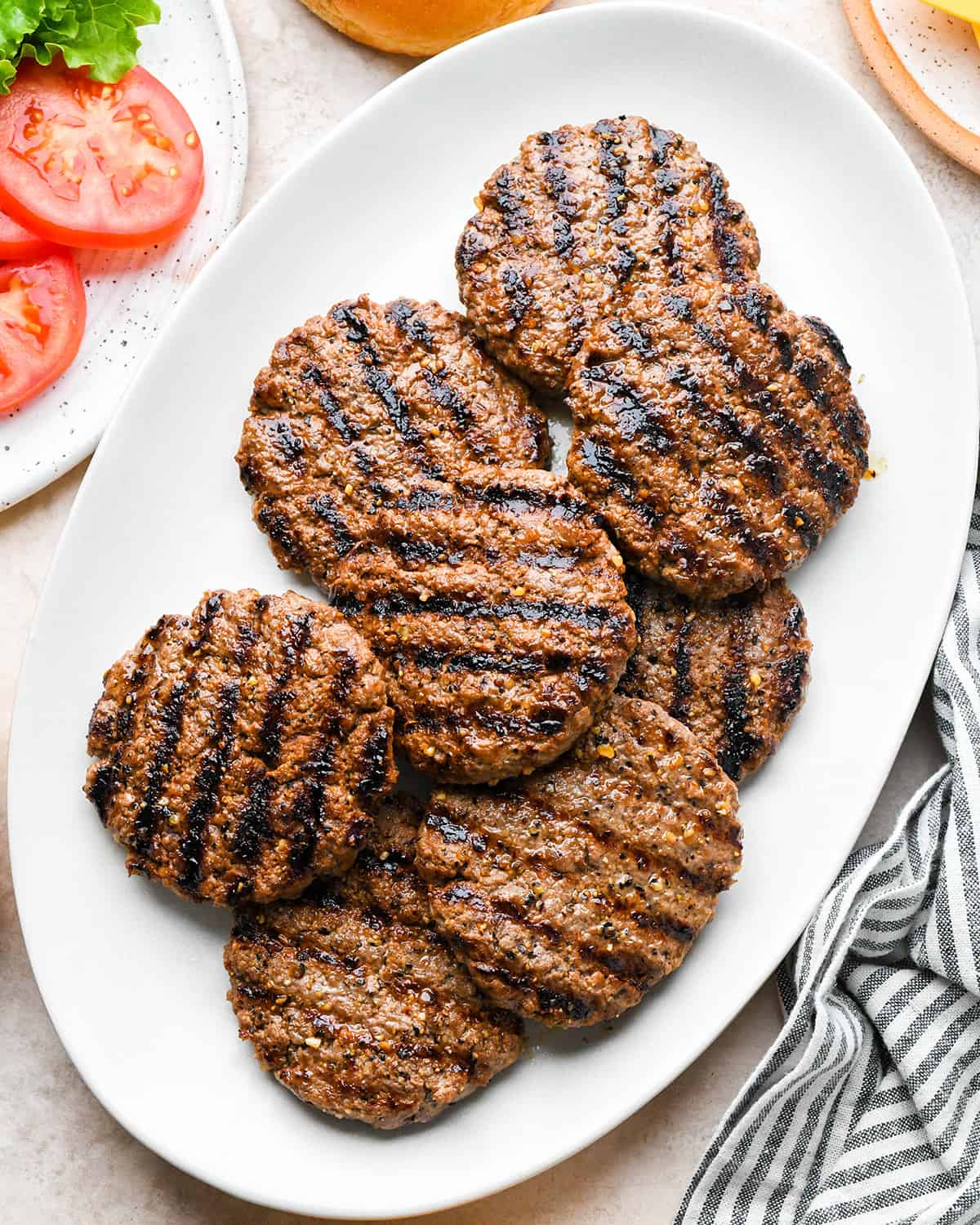 8 grilled hamburger patties on a plate