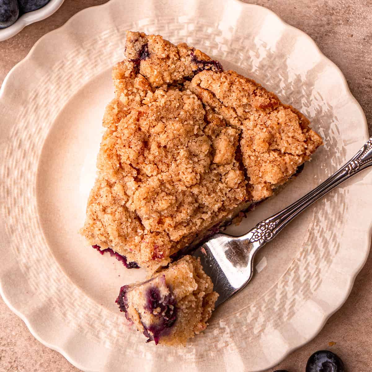 a slice of Blueberry Coffee Cake on plate with a fork 