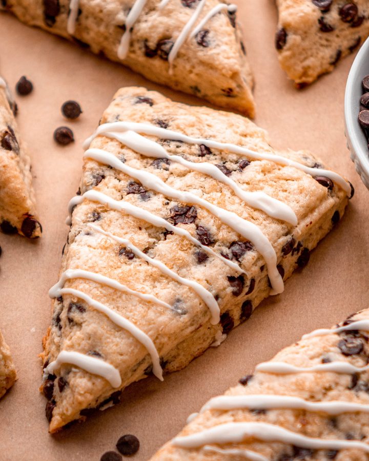 up close photo of a Chocolate Chip Scones with glaze drizzled on top