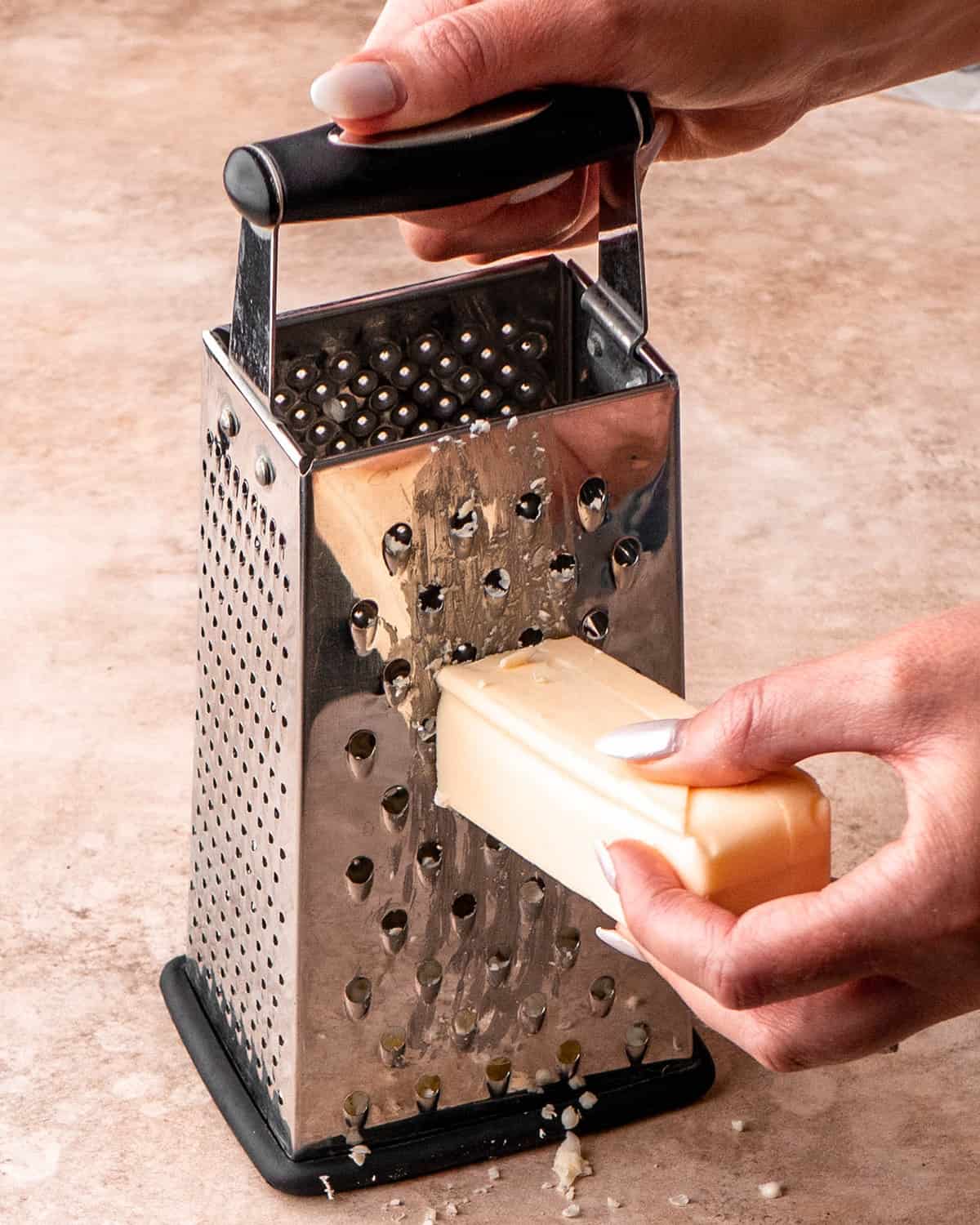 butter being grated with a box grater