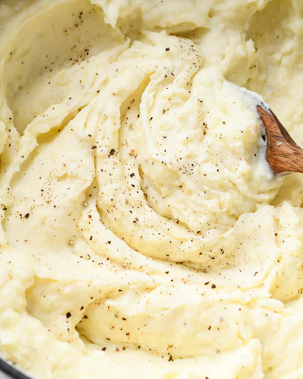 Cream Cheese Mashed Potatoes in a pot with salt and pepper sprinkled on top