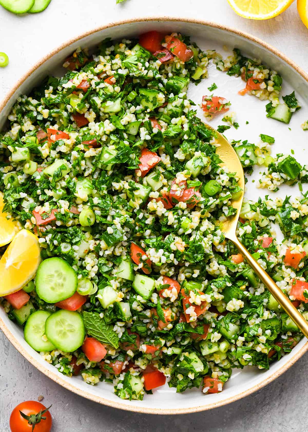 a spoon taking a scoop of Tabbouleh Recipe out of a serving bowl