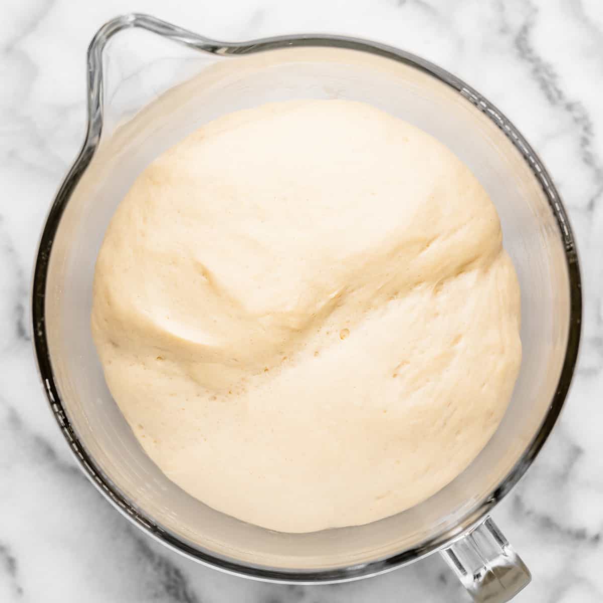 two photos showing How to Make Breadsticks - dough after rising in a glass mixing bowl