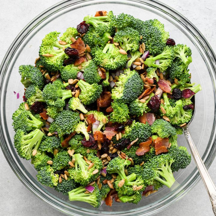 Broccoli Salad being mixed in a glass bowl