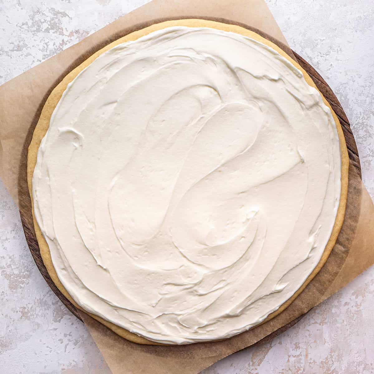 cream cheese frosting spread onto the sugar cookie crust to make fruit pizza